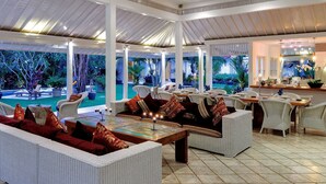 Un espacio interior amplio con piscina, asientos exteriores y zona de comedor.