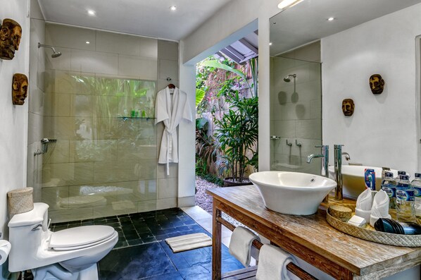 A modern bathroom with a glass-enclosed shower, a large sink, and a mirror. - Villa Sipo (Seminyak)
