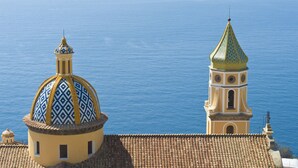 A building with a dome and a bell tower overlooking the sea. - Casa Agata (Praiano)