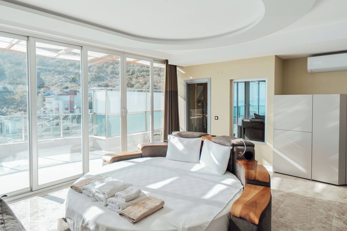 Une chambre moderne avec un grand lit, un bureau intégré et une vue sur la mer.