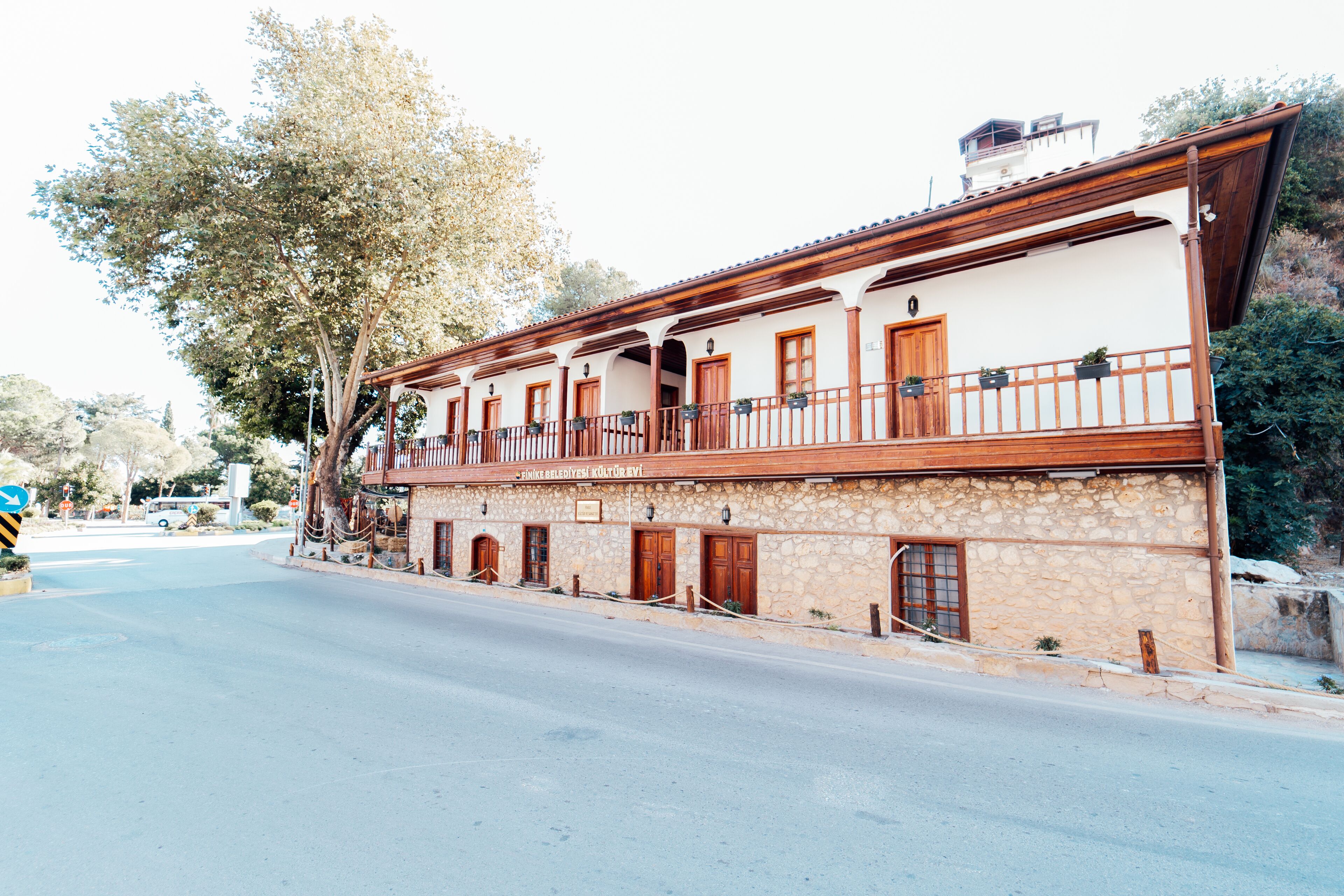 A two-story building with a stone facade, wooden balconies, and multiple doors.