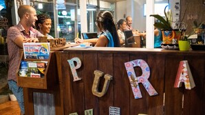 A wooden reception desk with the words "PURA VID" and decorative letters. - Bird of Paradise Hotel (Jacó)