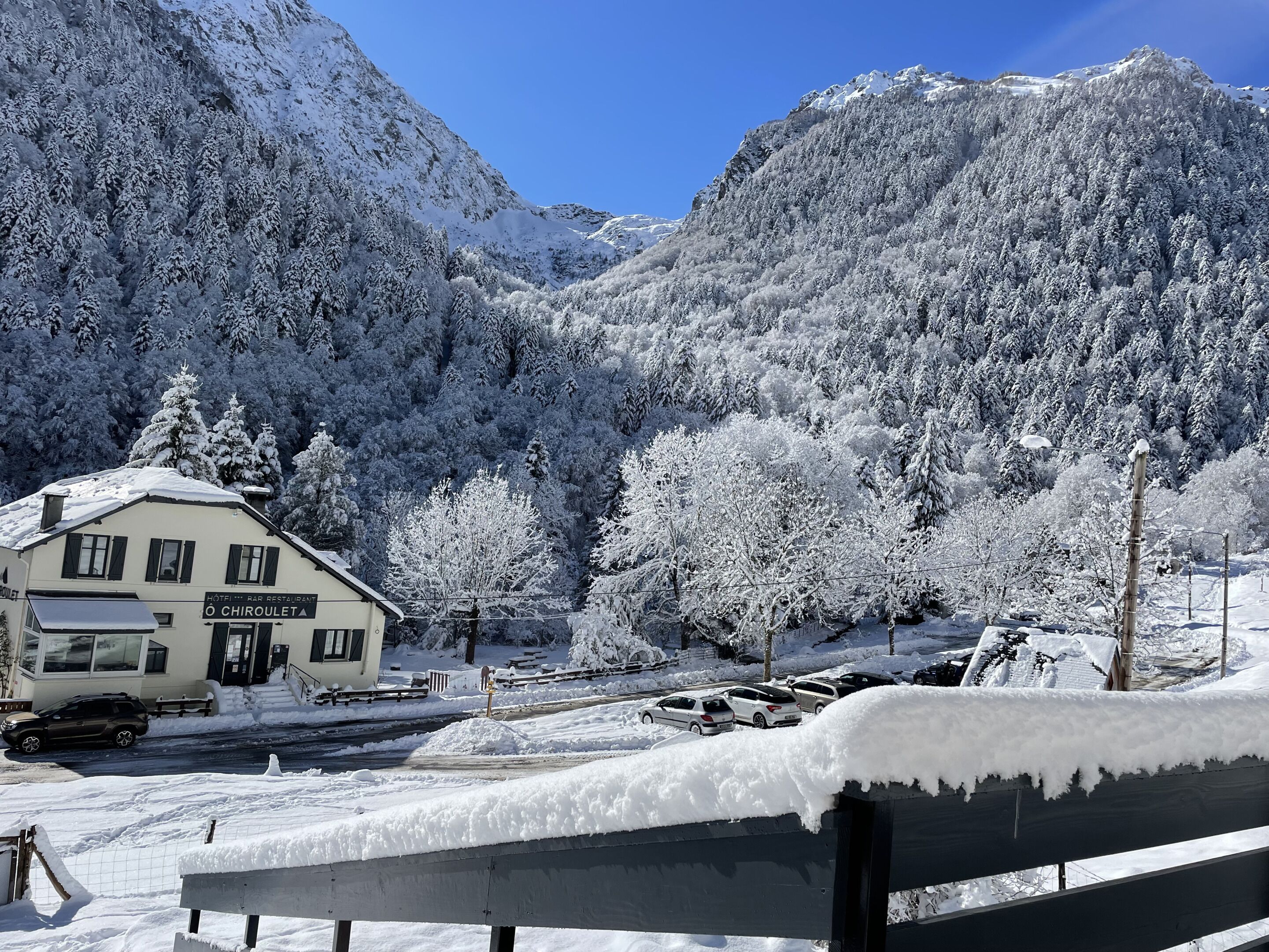 Un paysage montagneux enneigé avec un bâtiment portant l’inscription « HÔTEL ET RESTAURANT O CHIROULET ».