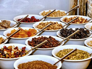 A buffet table with various dishes, including nuts, dried fruits, and other snacks.