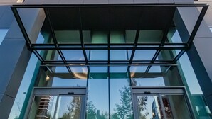 Un edificio moderno con fachada geométrica y grandes puertas de entrada de vidrio.