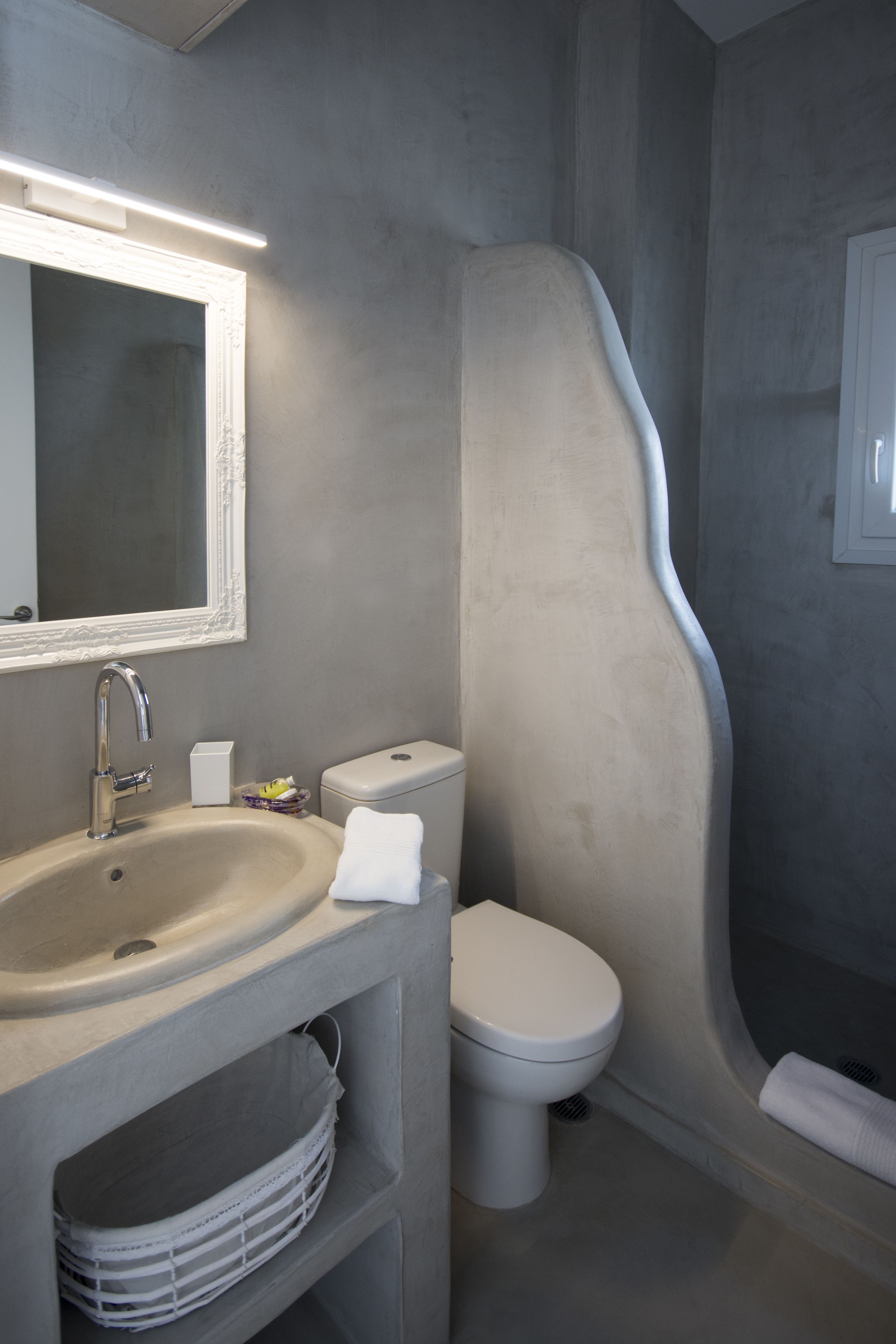 Une salle de bain équipée d’un lavabo, d’un miroir, de toilettes et d’une douche.