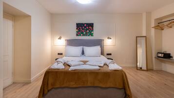 Quarto de hotel bem arrumado com uma cama, um quadro na parede e um espelho.