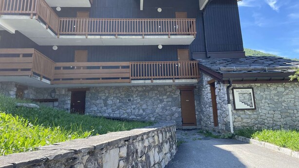 A multi-story building with balconies, stone walls, and a sign reading "Les Marches". - Marches 25 - 3 room duplex apartment, overlooking the slopes (LES AVANCHERS VALMOREL)