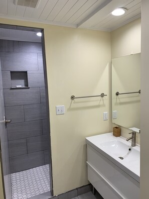 Bathroom features a white sink, silver faucet, and geometric tile floor.