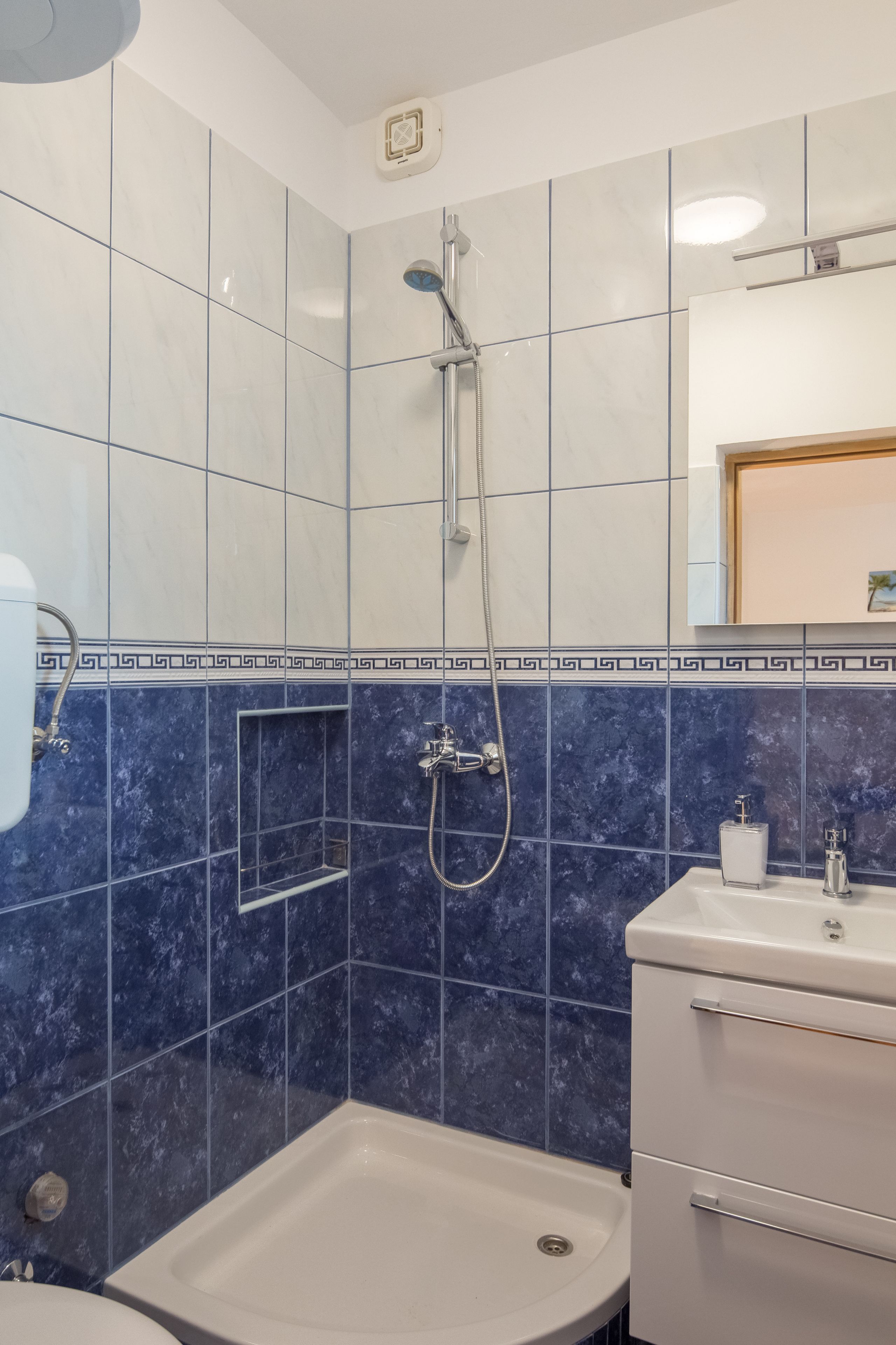 Une salle de bain avec une douche, un lavabo et des toilettes.