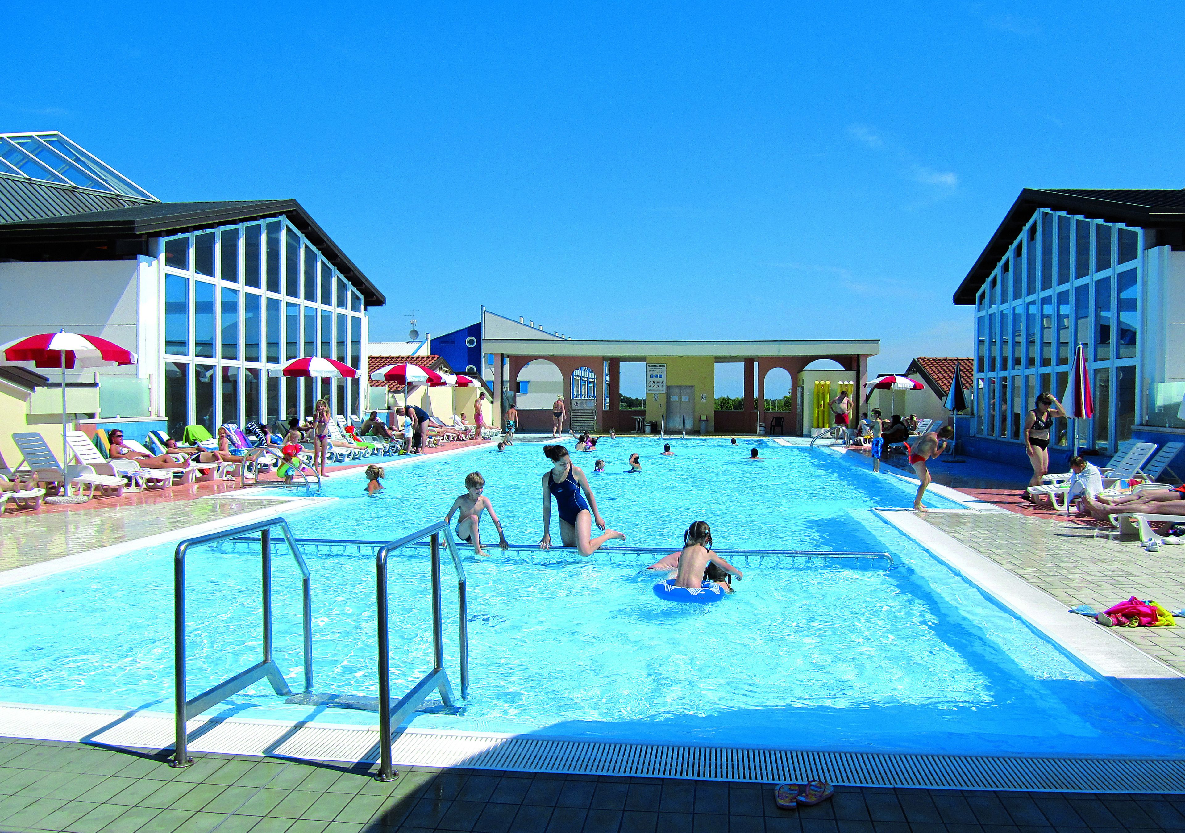 Una piscina al aire libre de temporada, sombrillas