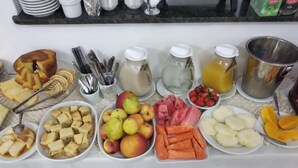 Un bufé de desayuno con diversas frutas, verduras y bebidas.