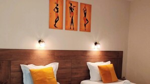 Two twin beds with wooden headboards, white linens, and orange pillows. - Hotel Sorbona (Varna)