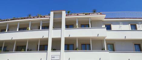 A multi-story hotel with balconies, stone facade, and a sign indicating 'Montecarlo Maison'.