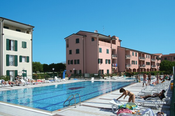 Piscine extérieure en saison, parasols, chaises longues