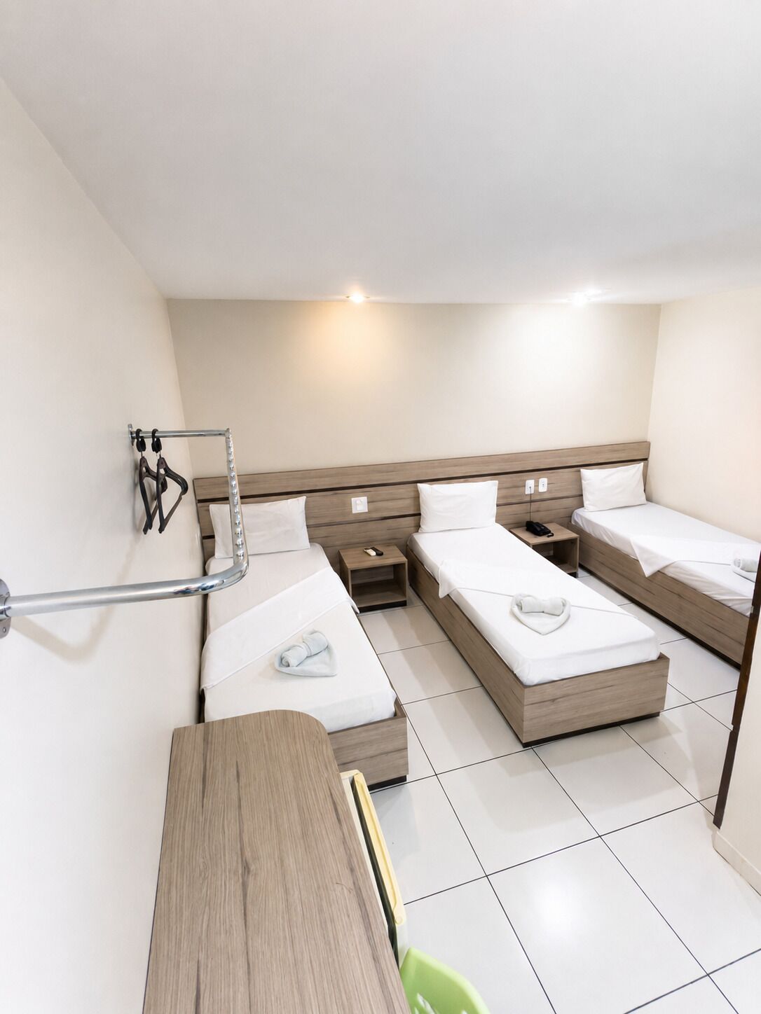 Una habitación de hotel con una cama, mesitas de noche, un escritorio y una silla.