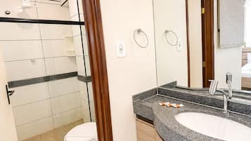 A modern bathroom with a shower, toilet, and sink.