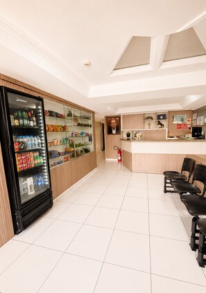 A hotel lobby with a vending machine, a reception desk, and a fire extinguisher.