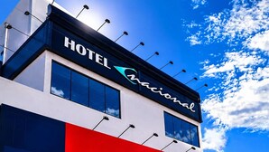 A modern hotel building with a prominent sign reading 'HOTEL Nacional' and a clear blue sky with clouds in the background. - Hotel Nacional (Arapiraca)