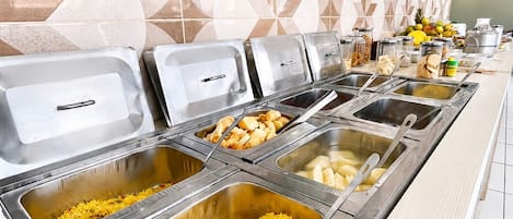 Un bufé con diversos platillos, incluyendo arroz y otras opciones.