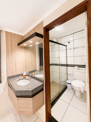 A modern bathroom with a wooden vanity, two sinks, a glass shower enclosure, and a toilet. - Hotel Nacional (Arapiraca)