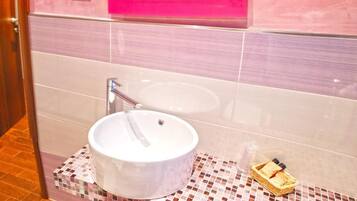 A bathroom with a white sink, a pink-framed mirror, and a tiled floor.