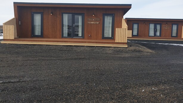 A modern wooden building with large windows and a sign reading "Black Beach Small Cottage 3". - Black Beach Small Cottage (Sveitarfélagid Ölfus)