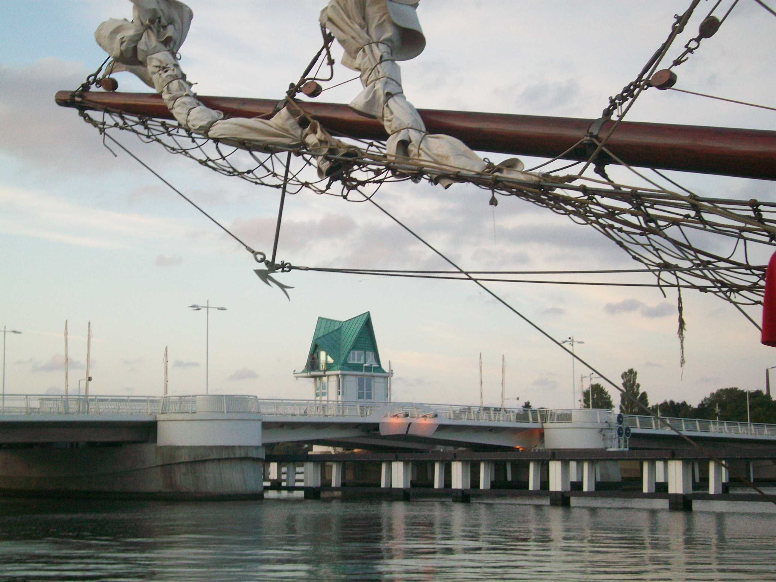 Un ponte con un edificio a tetto verde sullo sfondo.