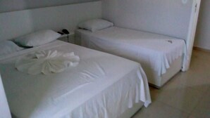Ein Hotelzimmer mit zwei Einzelbetten, jeweils mit weißer Bettwäsche und Kissen.