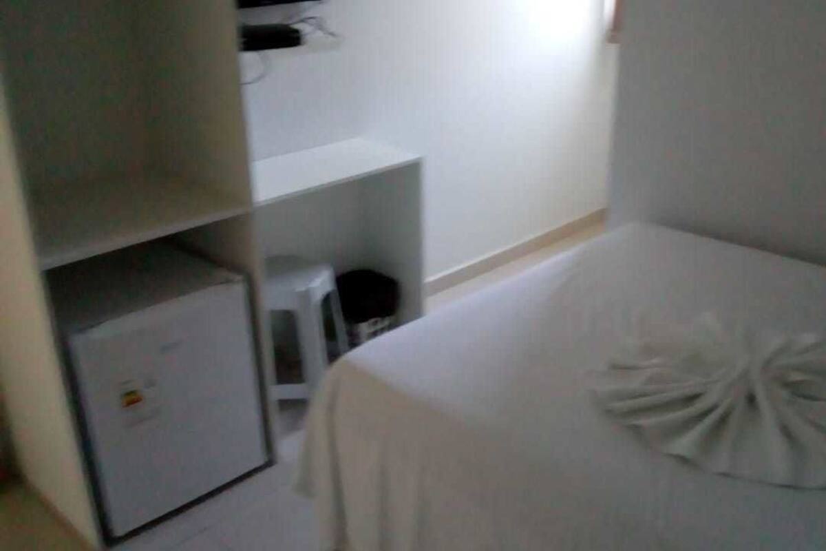 A hotel room with a bed, a small desk, and a wardrobe.