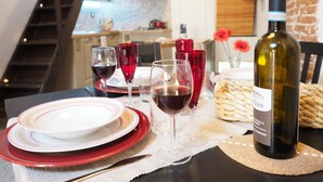 A dining table set with plates, glasses, and a bottle of wine. - Caratteristica Dimora Della Galera (Genoa)