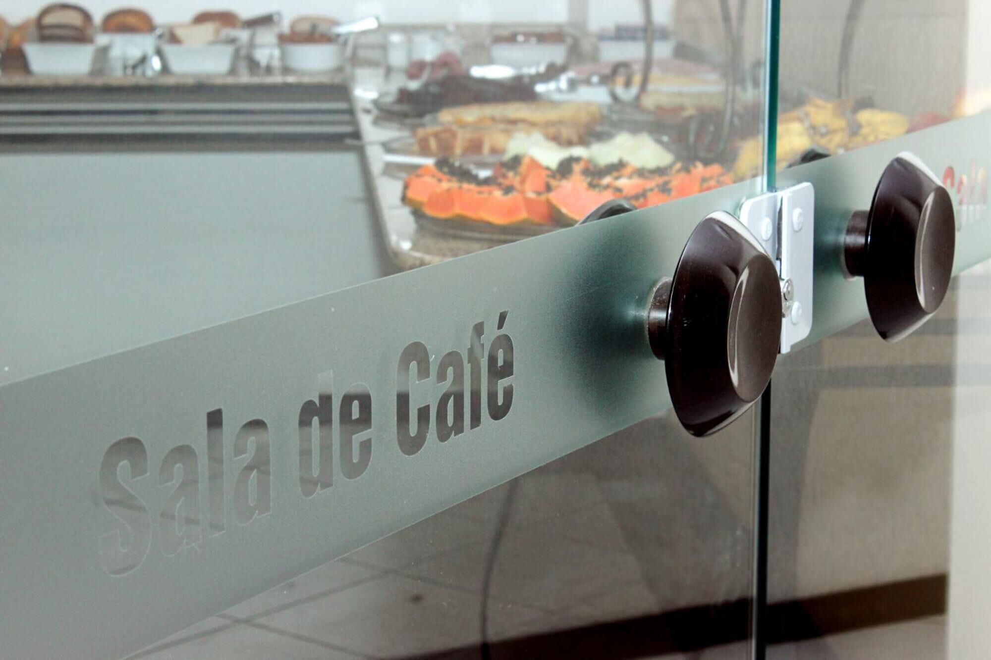 A glass partition with the text "Sala de Café" indicating a café area.