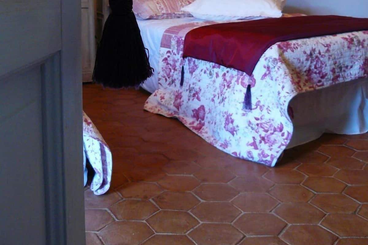 A bedroom with a bed, a wardrobe, and a stone-patterned wall.