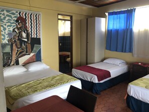 Ett hotellrum med två sängar, ett badrum och en väggmålning.