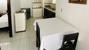 Ein kompakter Wohnraum mit Essbereich, Küchenzeile und einem kleinen Schlafzimmer.