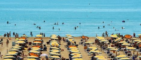 Vlak bij het strand, ligstoelen aan het strand, parasols