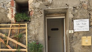 Un edificio rústico de piedra con puerta de madera y un letrero que indica que es una casa de huéspedes llamada "La Voiture".