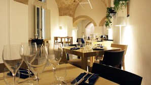 A dining area with tables set for a meal, featuring clear glassware and napkins. - Palazzo Sambiasi (Lecce)