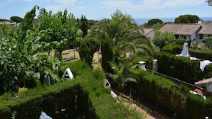 Een weelderige tuin met diverse planten en uitzicht op zee.