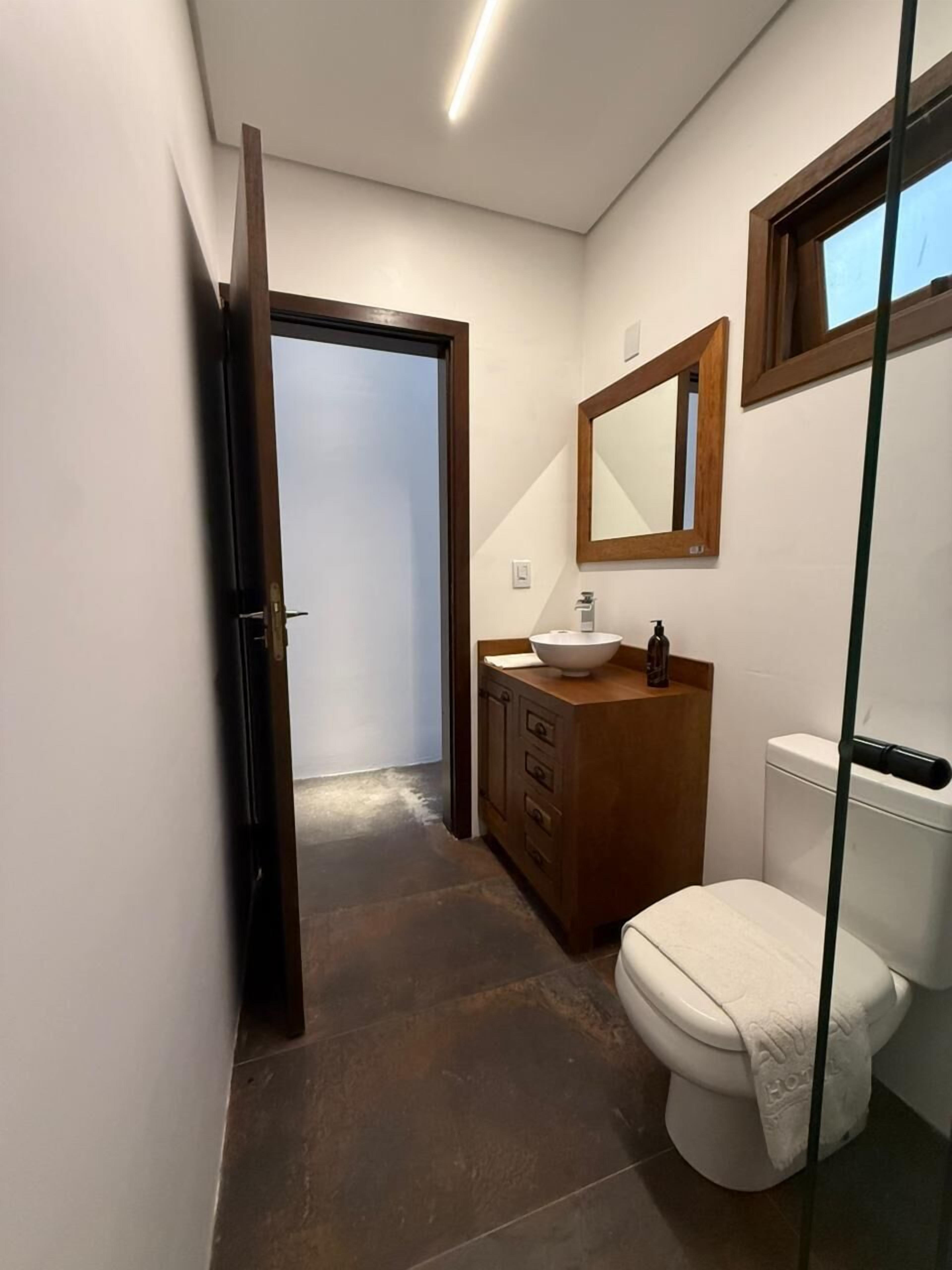 A modern bathroom with a toilet, sink, and mirror.