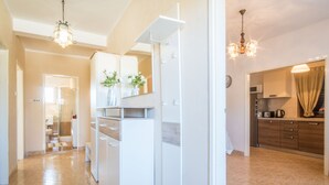 A modern kitchen with white cabinets, a built-in oven, and a microwave. There is a dining area with a table and chairs. - Top vacation home with pool for 4+1 (Tinjan)