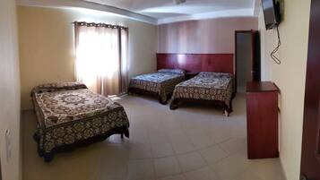 Habitación triple Confort | Edredón, espacio para trabajar con laptop y cortinas blackout