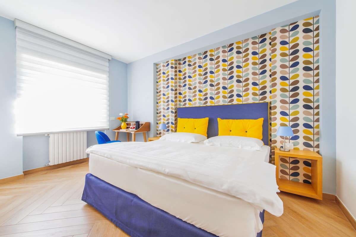 A bedroom with a bed, a desk, and a chair.