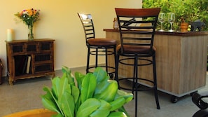 A bar area with two chairs, a wooden cabinet, and a potted plant. - Casa Bul-Kay's- Where Confort Meets Consierge Care (Dzemul)