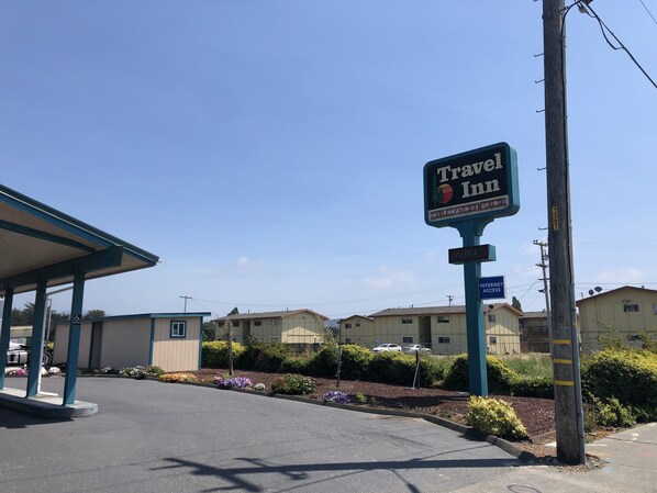 A Travel Inn sign, a handicap accessible building, and a parking area with a covered structure.