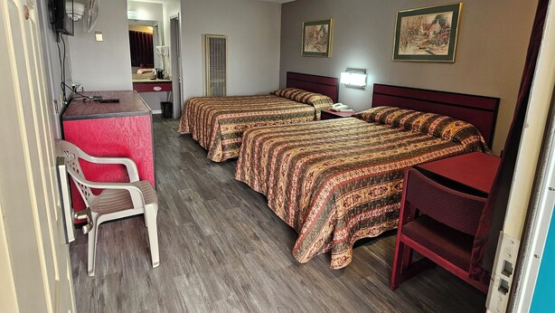 A hotel room with two beds, a desk, a chair, and a TV. - Travel Inn (Fortuna)