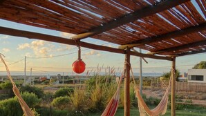 Eine Holz-Pergola mit einer Hängematte und einem roten Ball.