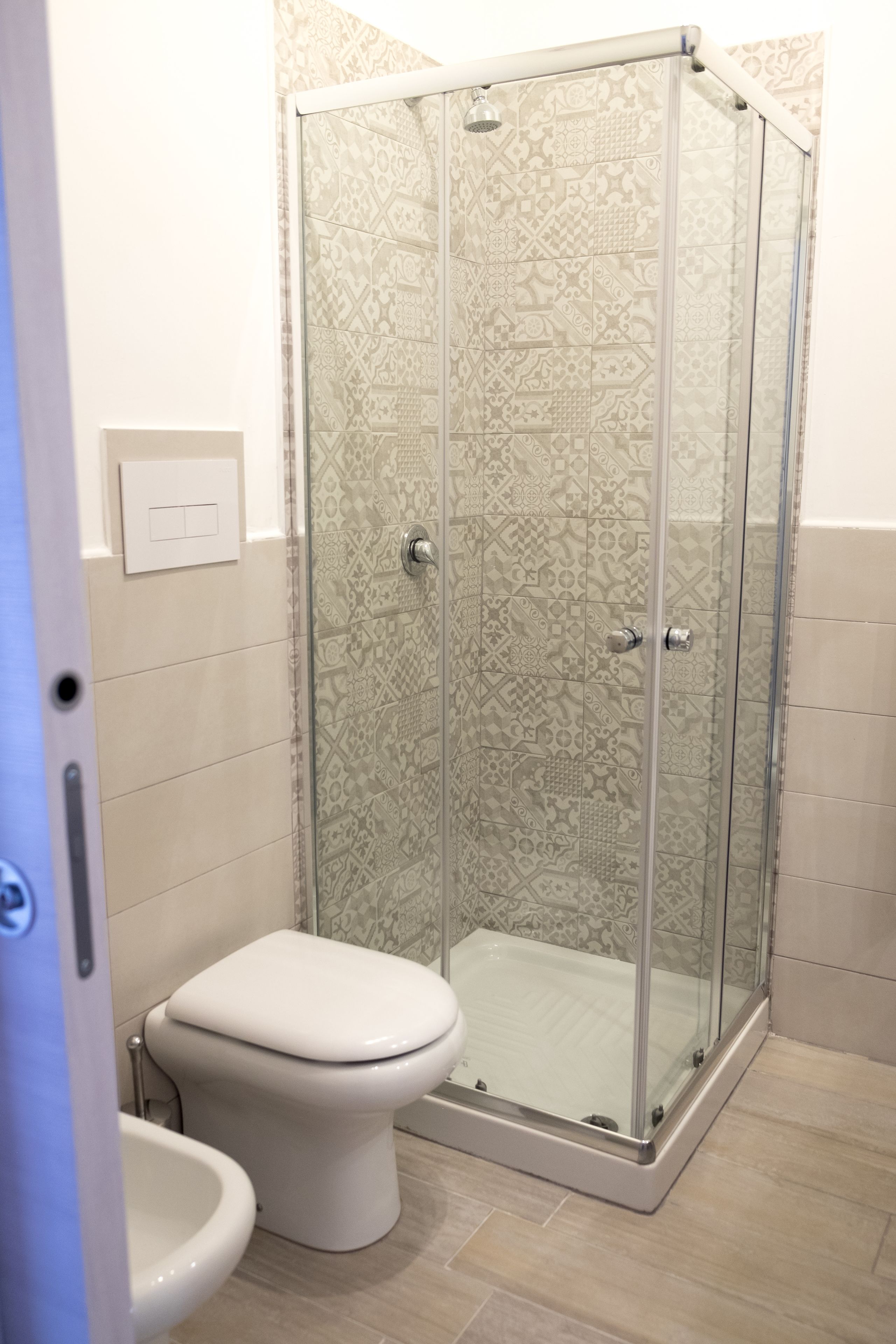 Un baño con ducha acristalada, inodoro y bidé.
