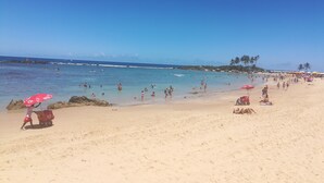 A beach with people swimming and sunbathing. - Pousada Borboleta (Cairu)