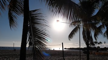 Perto da praia, areia branca, espreguiçadeiras, guarda-sóis